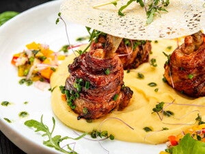 Carne en forma de rollitos con una base de pure de papas