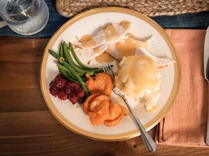 Un plato que contiene vegetales, pure de papa y pollo