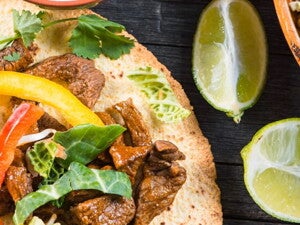 Fajitas rellenas con res y una salsa con limones a un lado