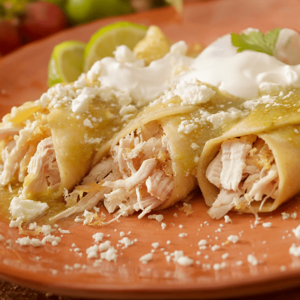 Tres burritos de pollo con salsa en un plato marrón