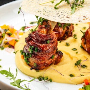 Carne en forma de rollitos con una base de pure de papas