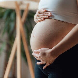 Primer plano de una mujer embarazada acariciándose el vientre. Contracciones en el embarazo.