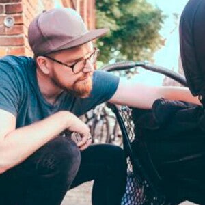 Conoce los consejos para comprar el coche para niños. Mamá y papá mirando a su niño en la carriola.