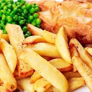 Un plato contiene papas en julianas con arbejas y  pescado