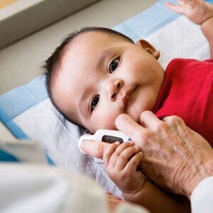 Profesional de salud midiendo la temperatura de un bebé