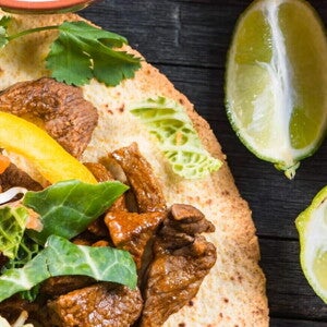Fajitas rellenas con res y una salsa con limones a un lado