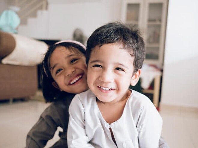 Dos mellizos felices jugando en casa.