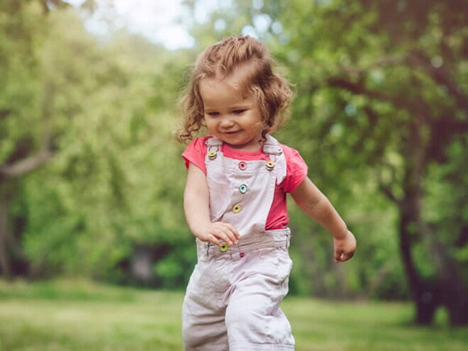 Una niña caminando en un parque.