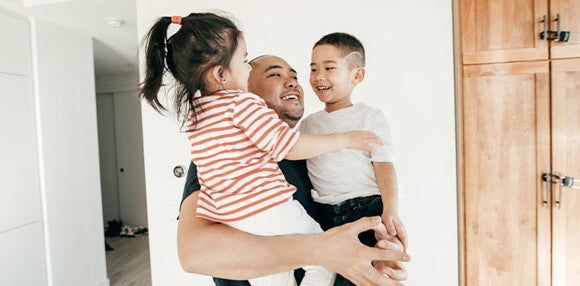 Papá alzando a sus hijos.