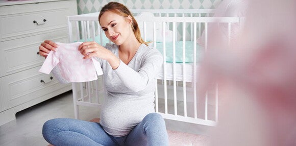 La mamá primeriza debe tener los artículos básicos de su hija. Mamá primeriza viendo los artículos básicos para su hija.