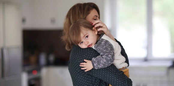 El llanto intenso es una manera de reconocer el cólico en tus hijos. Mamá primeriza cargando a su hijo llorando.